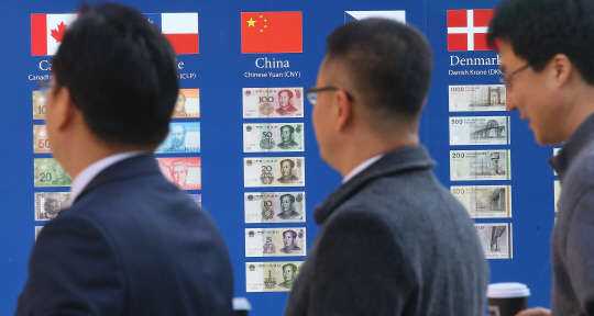 중국 위안화의 국제기축통화 편입이 결정된 1일 오후 서울 중구 KEB하나은행 화폐 전시물 게시판에 전시된 위안화 앞으로 시민들이 지나고 있다. 국제통화기금(IMF)은 11월 30일(현지시간) 워싱턴D.C. IMF 본부에서 집행이사회를 열고 위안화의 특별인출권(SDR) 편입을 선언했다. 편입 시점은 내년 10월 1일부터로 알려졌다.  연합뉴스